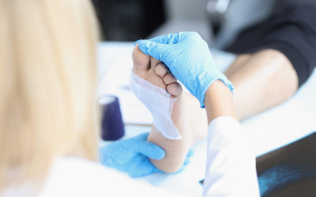 A doctor treats a patient's foot wound.
